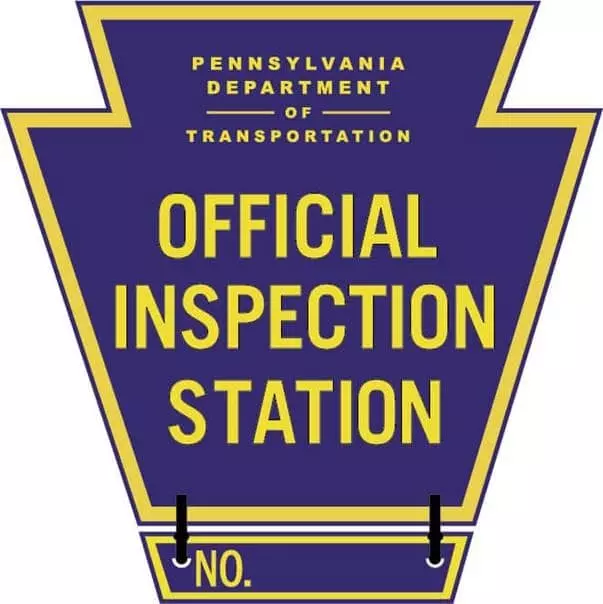 A blue and yellow keystone serving as an Official Inspection Station sign.